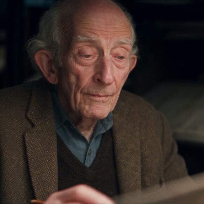 Still from THE SPIRAL showing an elderly animator reviewing artwork at a drafting table, from Moonrock’s Untitled AI Filmmaking System case study.